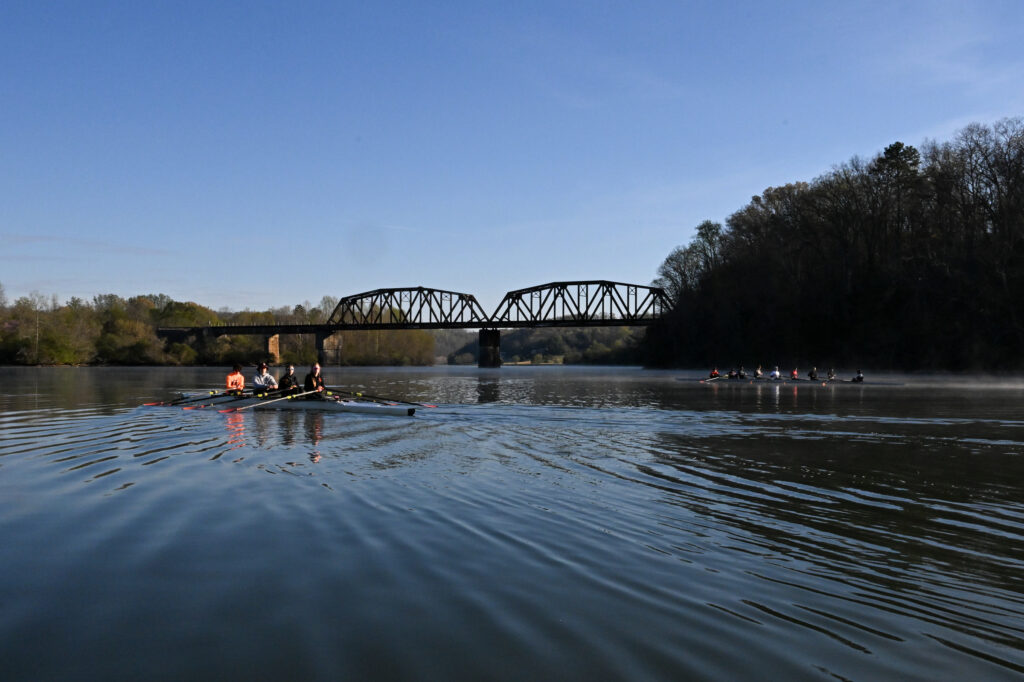 Northville Rowing training at sunrise under a river bridge at Oak Ridge, Tennessee, showcasing calm water, teamwork, and early‑morning discipline.